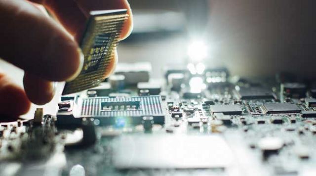 hand working on a computer chip