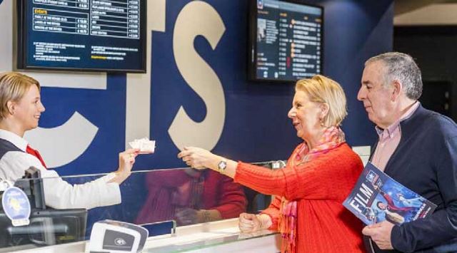 A couple getting tickets from a ticket agent