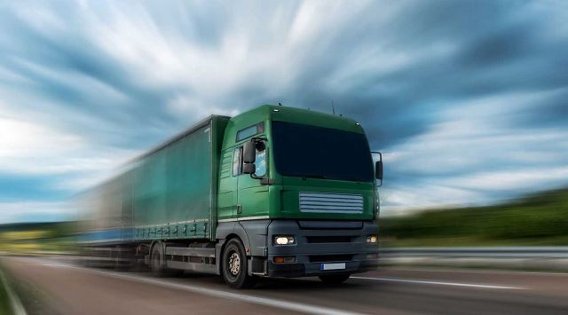 Grüner Sattelzug fährt schnell auf der Autobahn