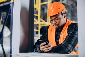 Homme portant un casque et utilisant un téléphone