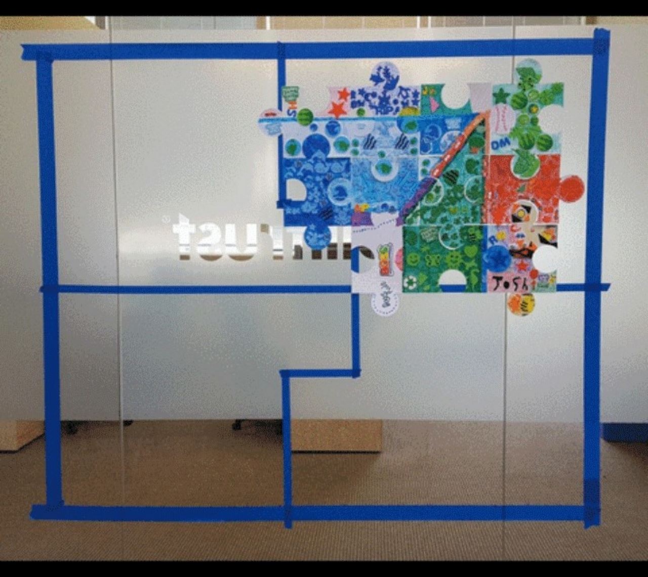 puzzle pieces on glass wall in Billtrust office creating the billtrust logo