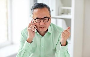 Professioneller älterer Mann telefoniert im Home-Office
