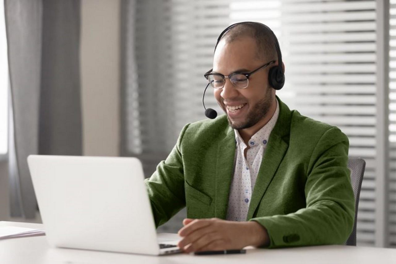 Homme élégamment vêtu participant à une téléconférence en utilisant un ordinateur portable dans un bureau