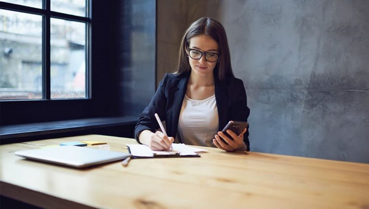 Business woman taking notes in a large office