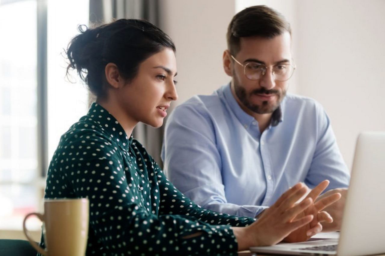 woman and man looking at a laptop