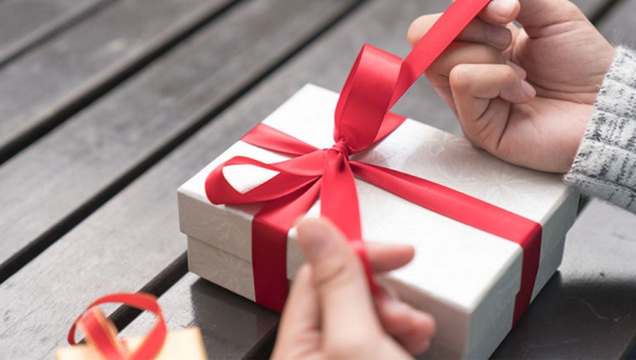 holiday gift box with a red ribbon tied around it