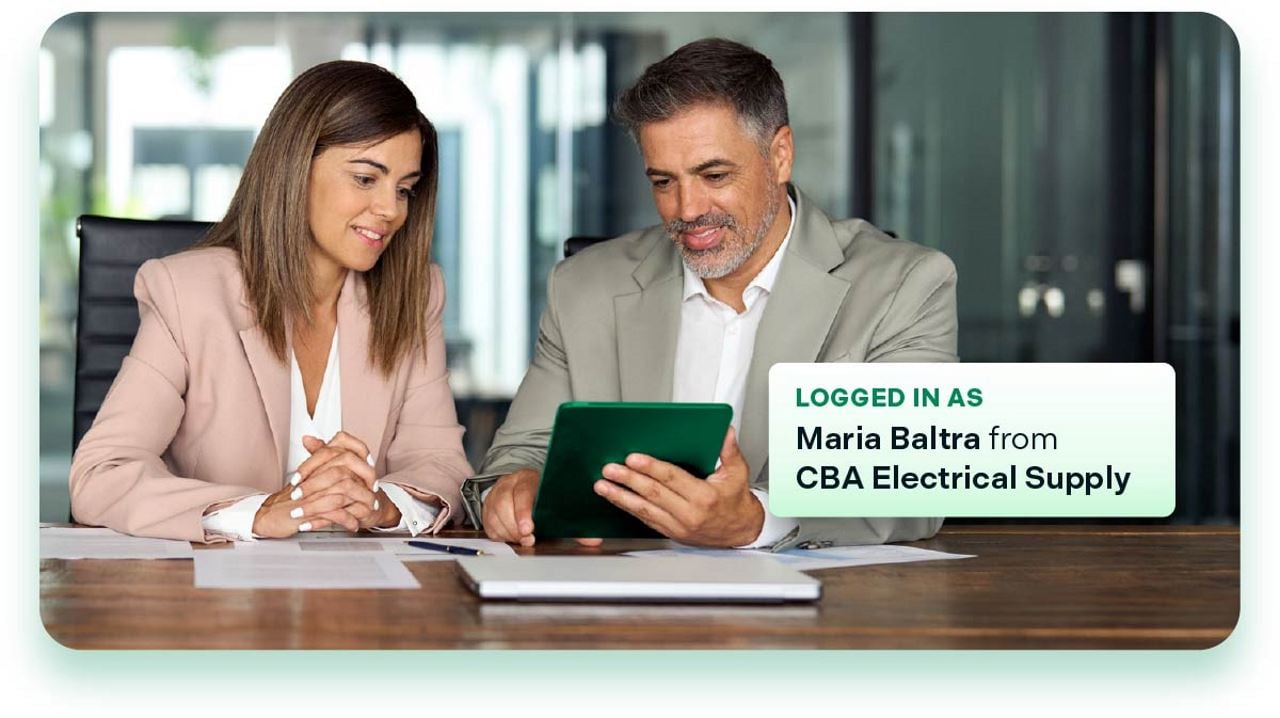 Two businesspeople looking at tablet displaying 'Logged in as: Maria Baltra from CBA Electrical Supply'