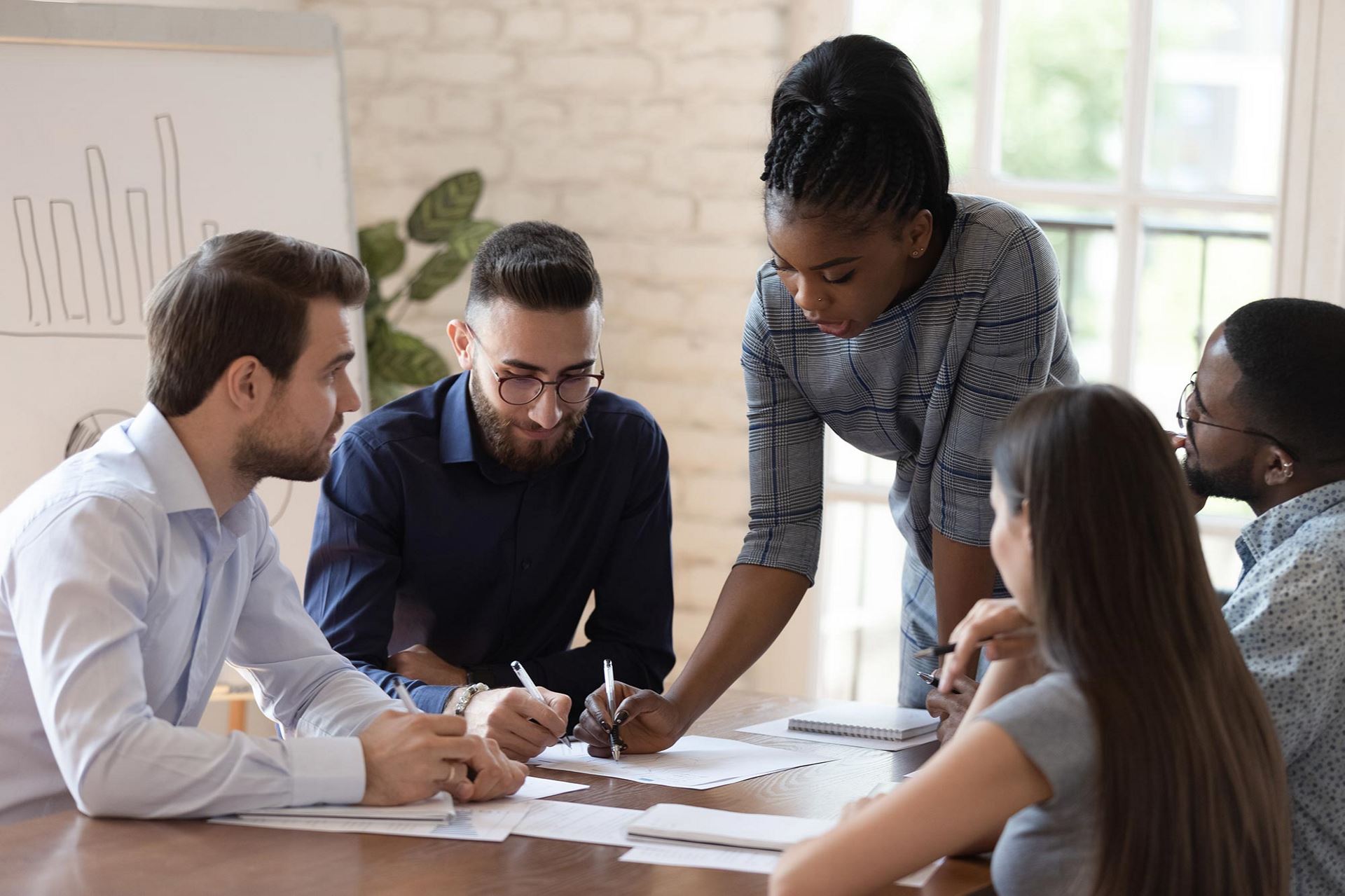 group of employees having a meeting and writing ideas in a conference room