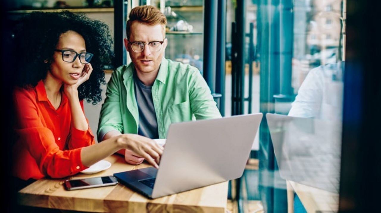 woman and man looking at a laptop screen in an office setting