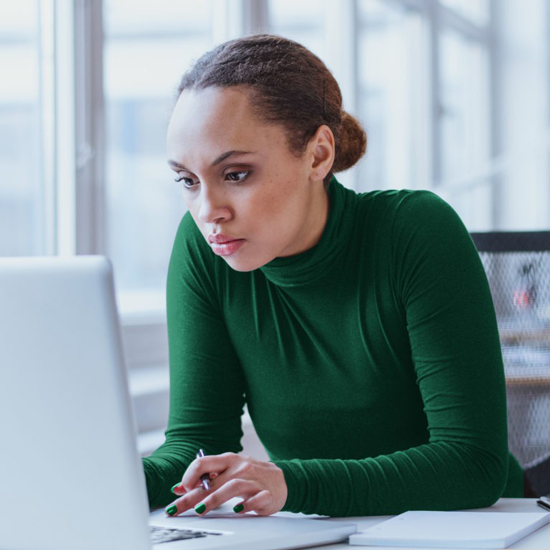 Woman at a laptop, researching robotic process automation and AR solutions