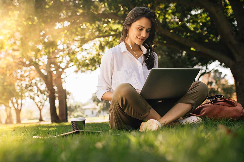 Frau benutzt Computer in der Natur