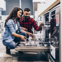 Man and woman looking at dishwasher in appliance store