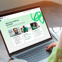 Person schaut auf Laptop, auf dem Billtrust-Schulungsportal für Kunden angezeigt wird