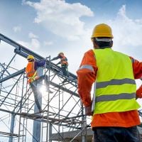 Construction worker looking up at building site