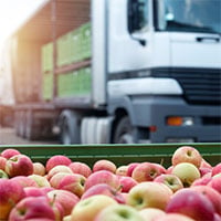 apples in crate with retail truck in background