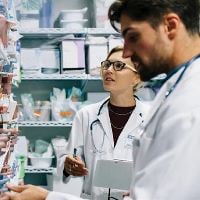 Two doctors looking at a shelf of medicine