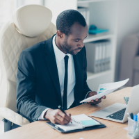 Employee reviewing spreadsheets and taking notes on AR challenges