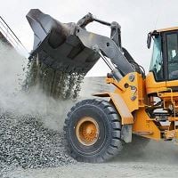 Loader dumping gravel onto a pile at a construction site