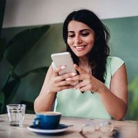 Woman looking at phone in cafe