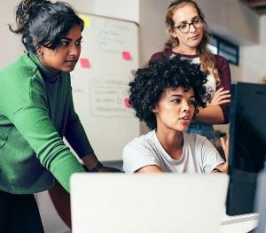 Three women working on computer together