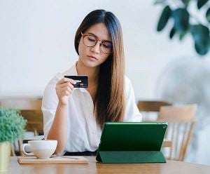 Une femme paie avec une carte bancaire sur une tablette