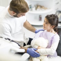 Zahnarzt spricht mit jungem Patienten