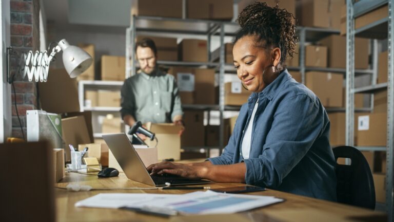 Employee using laptop in a warehouse