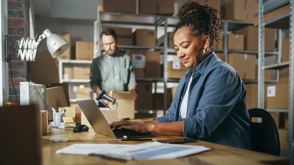 Employee using laptop in a warehouse