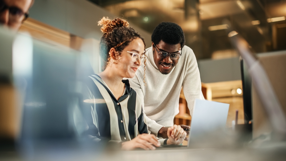 Two colleagues working at computer together