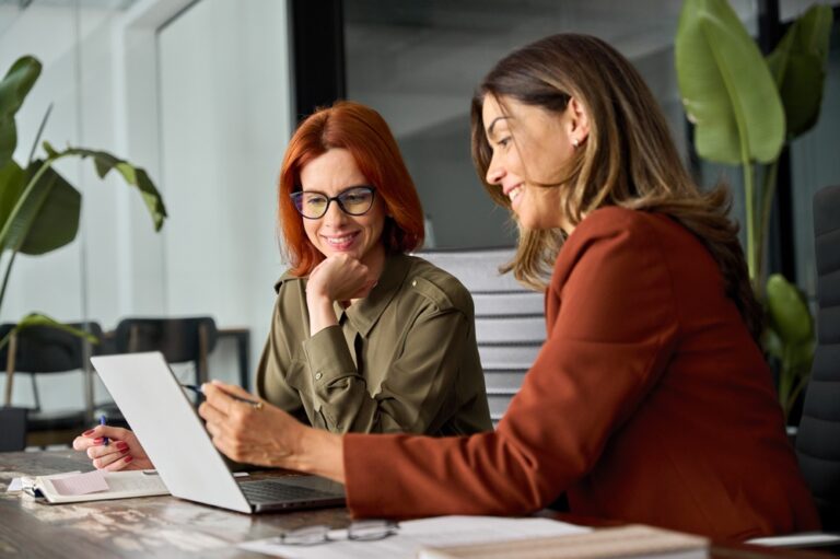 Two female colleagues using computer together