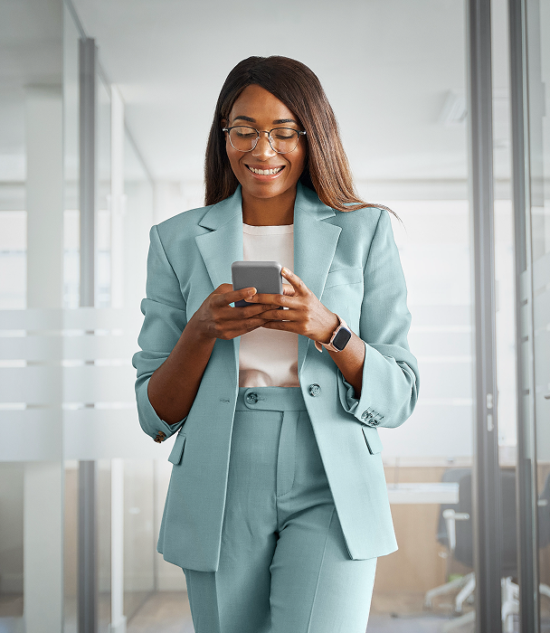 Professional young woman wearing a light blue suit holding a cellphone