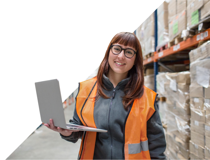 Vrouw in oranje vest met laptop in industriële setting
