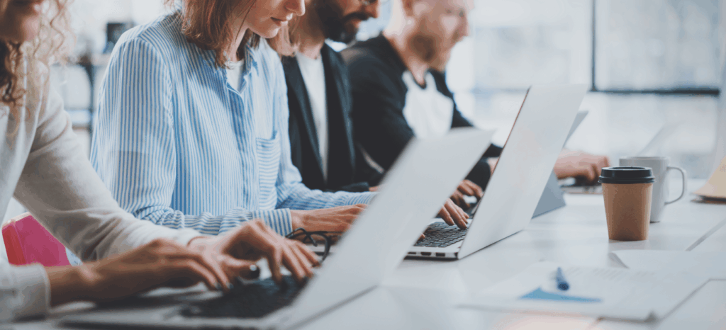 4 hidden costs of ar technology_employees in an office sitting in a row and working on their laptops