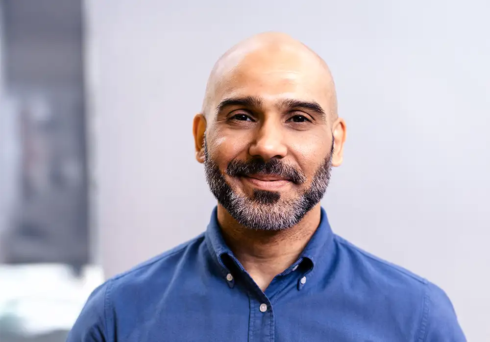 professional bearded man smiling at camera in office