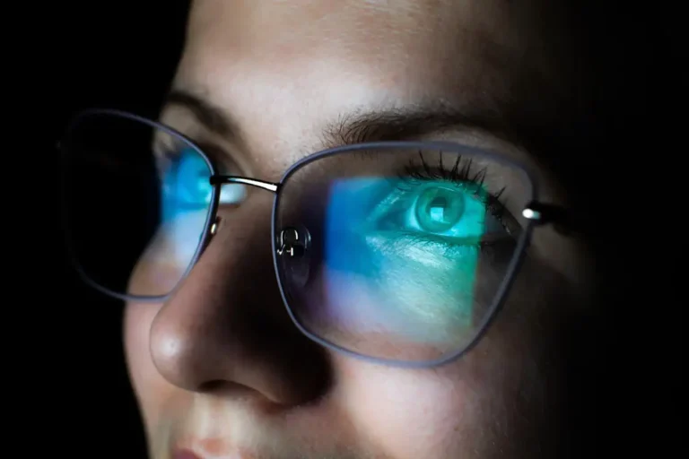 computer screen reflected in woman's glasses