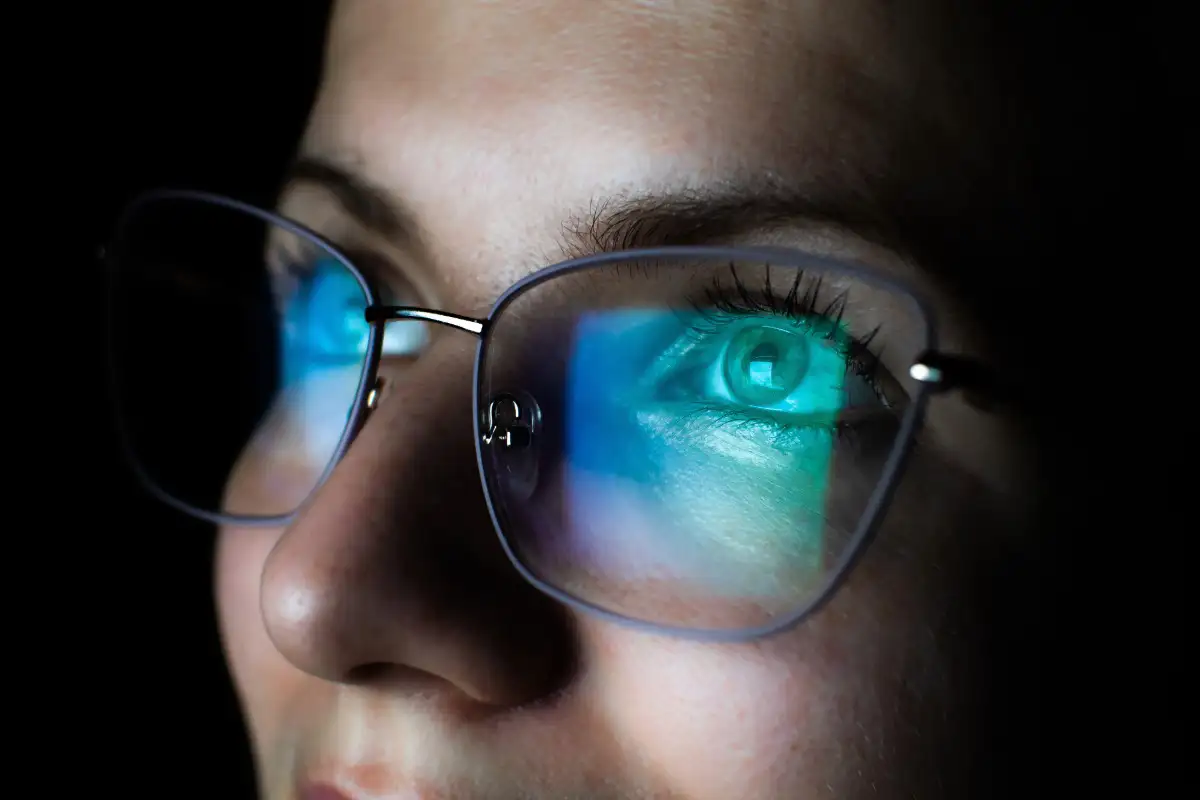 computer screen reflected in woman's glasses