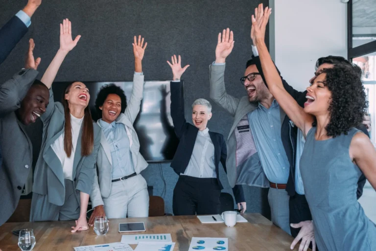 Team celebrating with hands in air