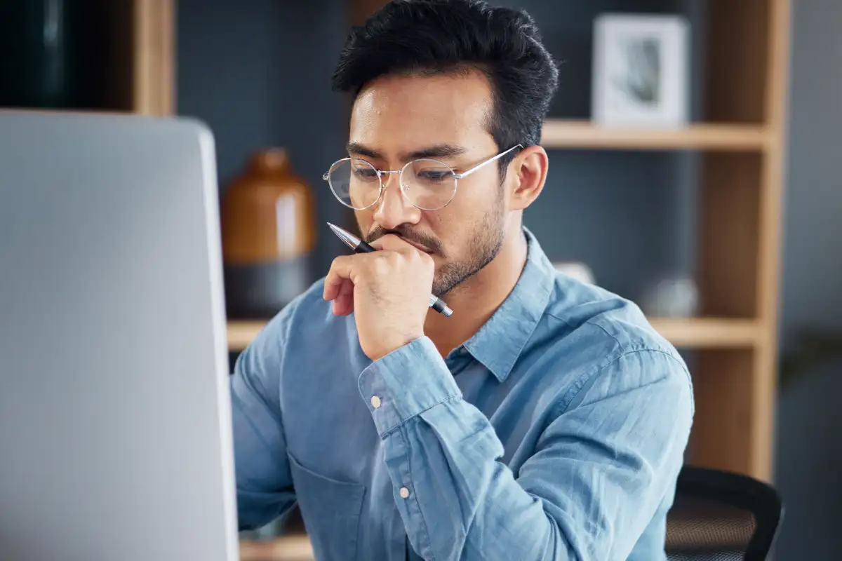man looking at computer and thinking