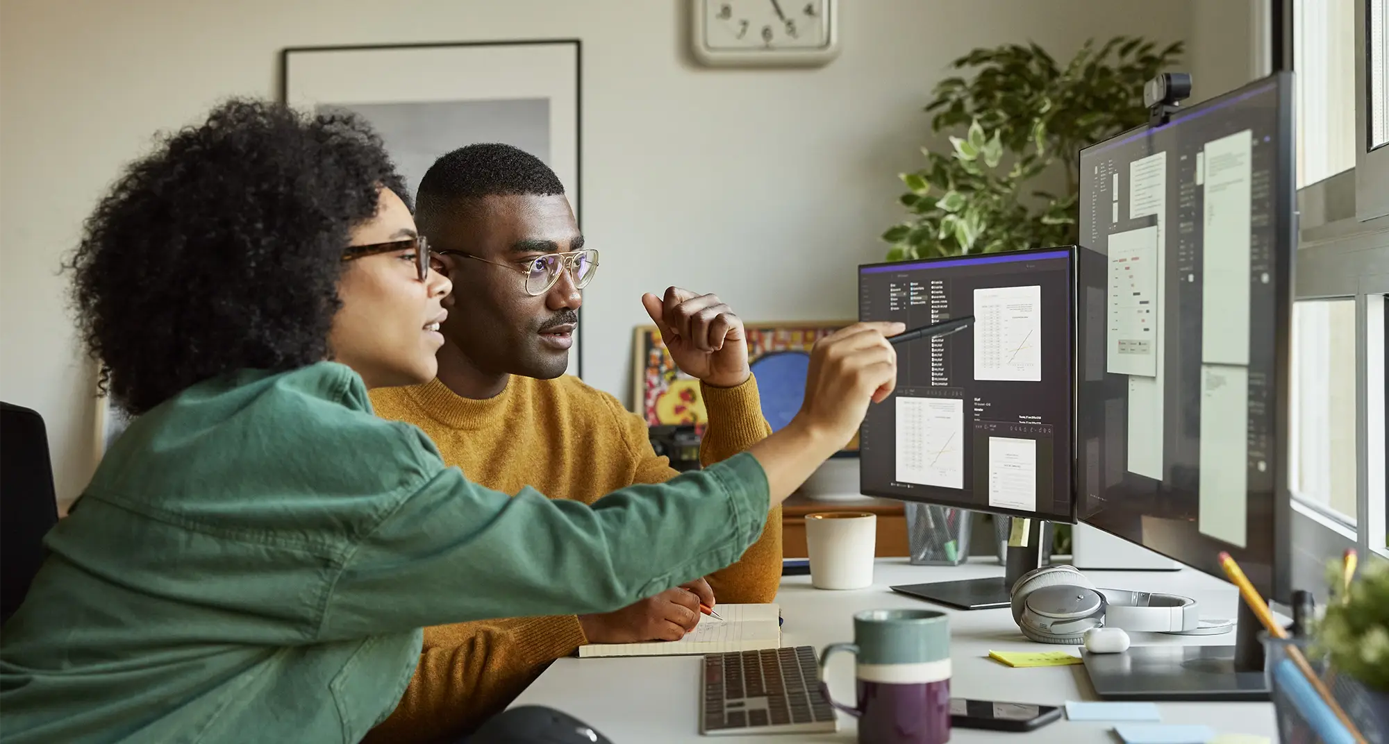 Colleagues looking at statistics on monitor