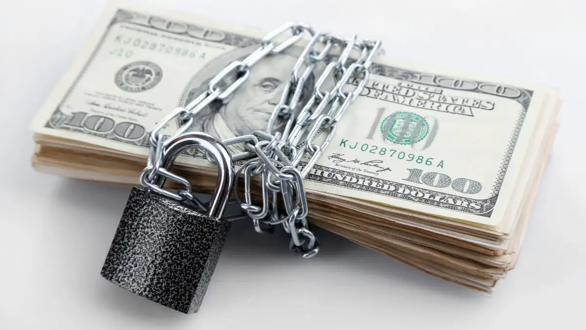 stack of money wrapped with lock and chain