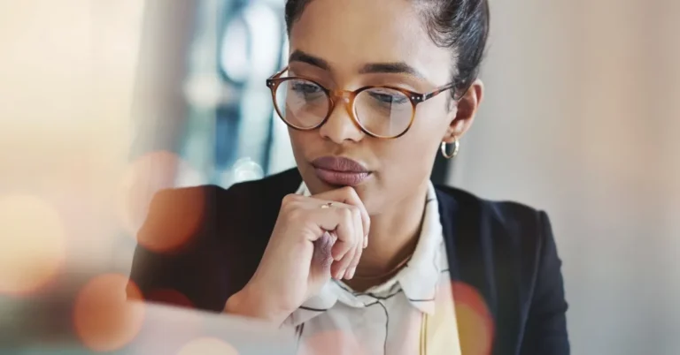 women wearing classes looking at computer thinking