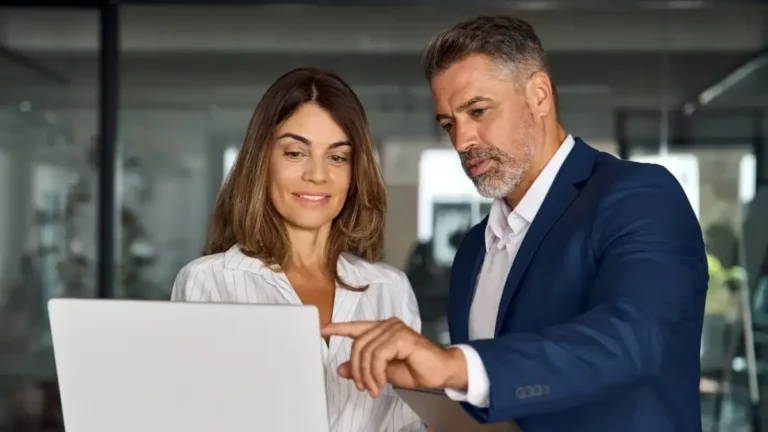 man and women looking at computer in office