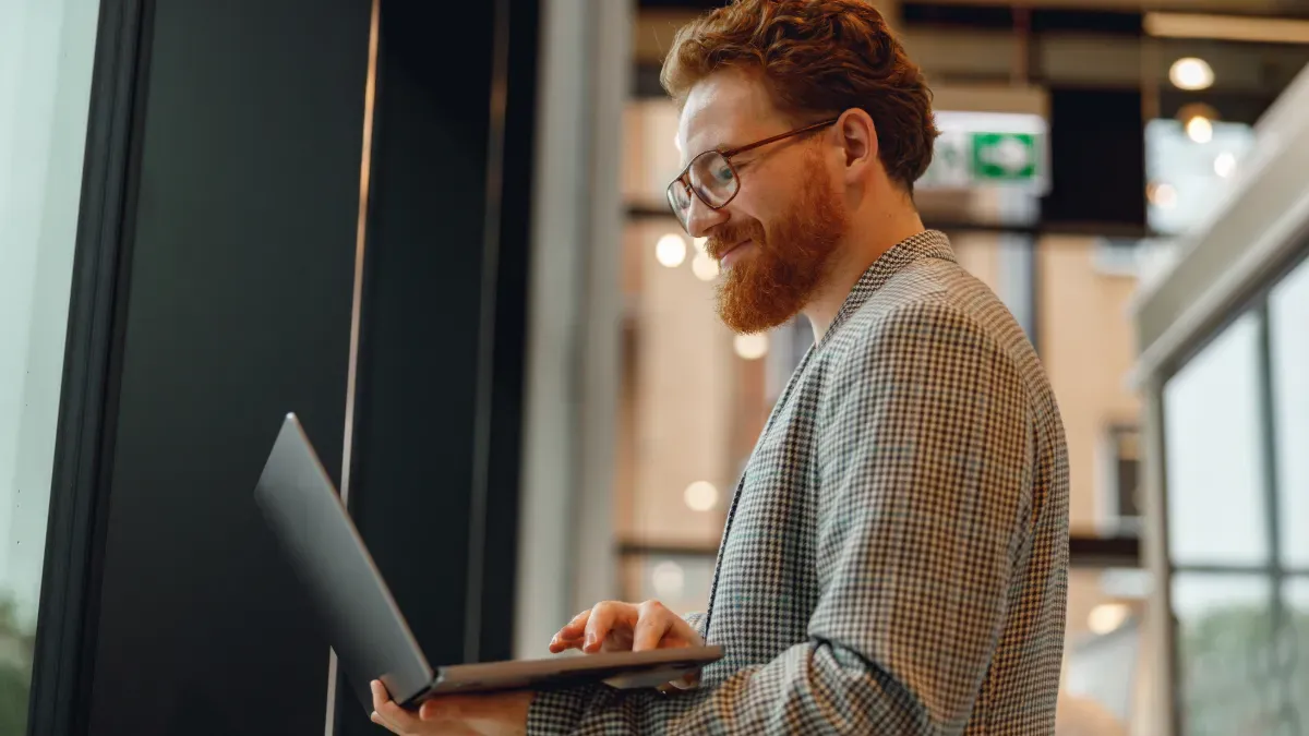 man wearing glasses looking at laptop