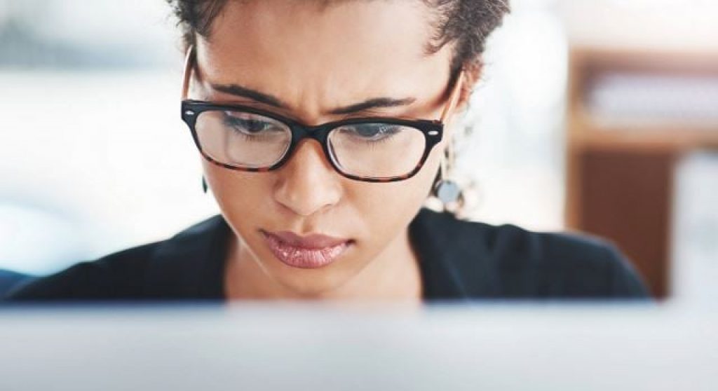 Woman looking concerned at computer screen