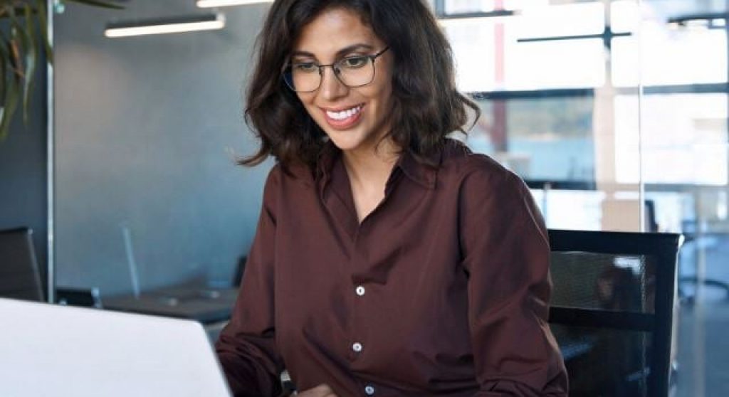woman in office looking at computer reading Billtrust IOFM Webinar Blog