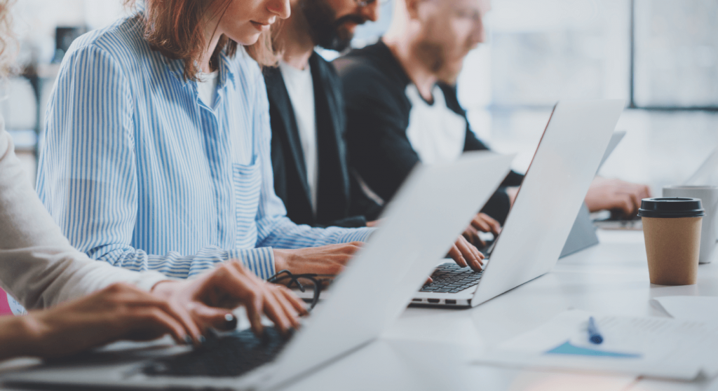 4 hidden costs of ar technology_employees in an office sitting in a row and working on their laptops