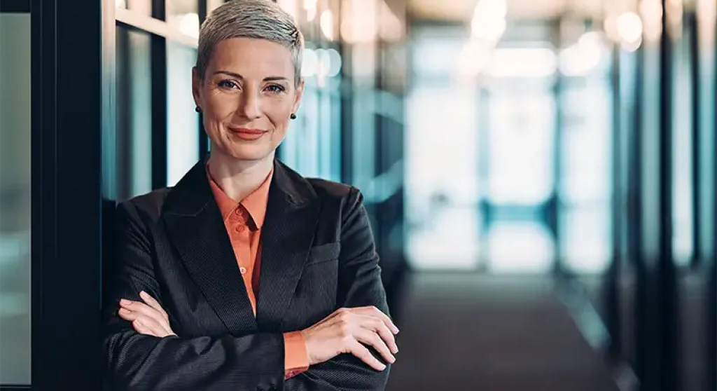 Law firm professional with arms crossed standing in office
