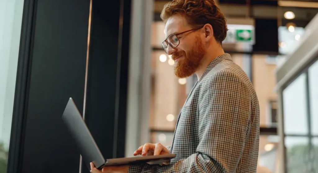 man wearing glasses looking at laptop