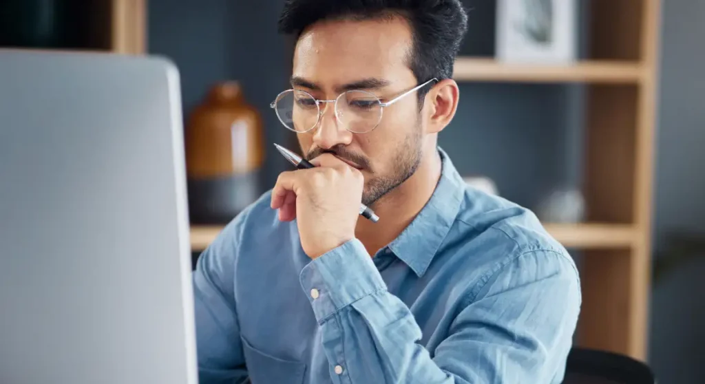 man looking at computer and thinking