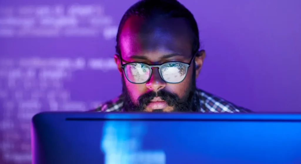 man looking at monitor wearing glasses